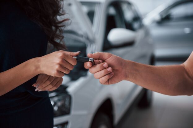 Homem recebendo as chaves do carro após contemplação em consórcio de veículo