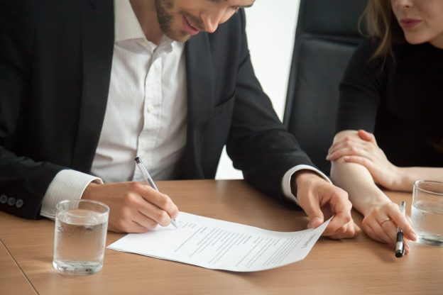 Cliente assinando contrato de cessão de direitos para vender consórcio cancelado com segurança e agilidade.
